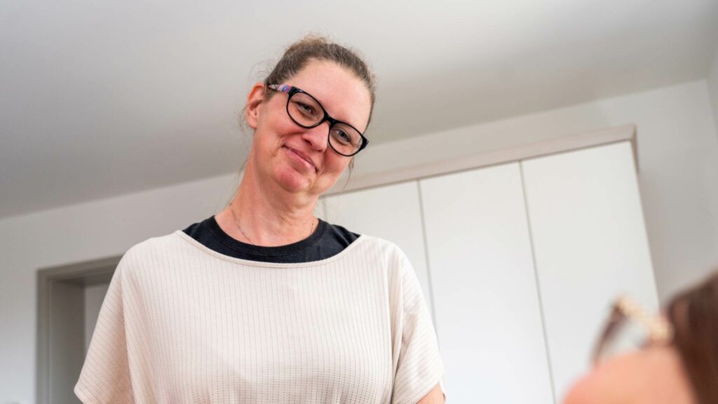 Eine Frau schaut lächelnd eine andere Person an