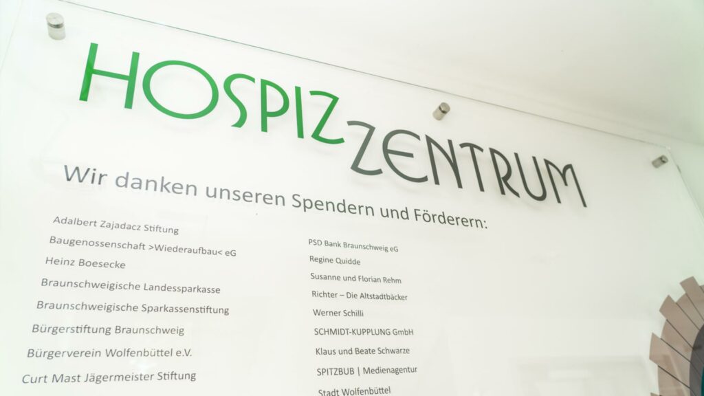 Hospiz Zentrum Wilkommensschild darauf steht " wir danken unseren Spendern und förderern: Adalbert Zajadacz Stiftung, Baugenossenschaft Wiederaufbau< eG, Heinz Boesecke, Braunschweigische Landessparkasse, Braunschweigische Sparkassenstiftung, Bürgerstiftung Braunschweig, Bürgerverein Wolfenbüttel e.V., Curt Mast Jägermeister Stiftung, PSD Bank Braunschweig eG, Regine Quidde, Susanne und Florian Rehm, Richter - Die Altstadtbäcker, Werner Schilli, SCHMIDT-KUPPLUNG GmbH, Klaus und Beate Schwarze, SPITZBUB | Medienagentur, Stadt Wolfenbüttel"