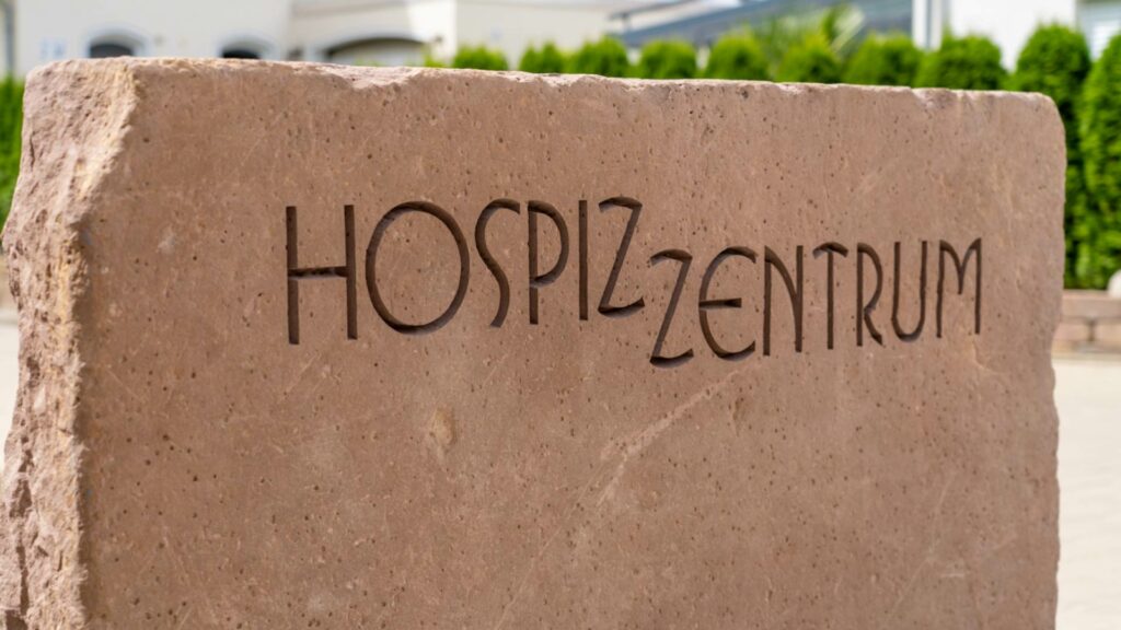 Auf einem großen Stein ist Hospizzentrum eingraviert